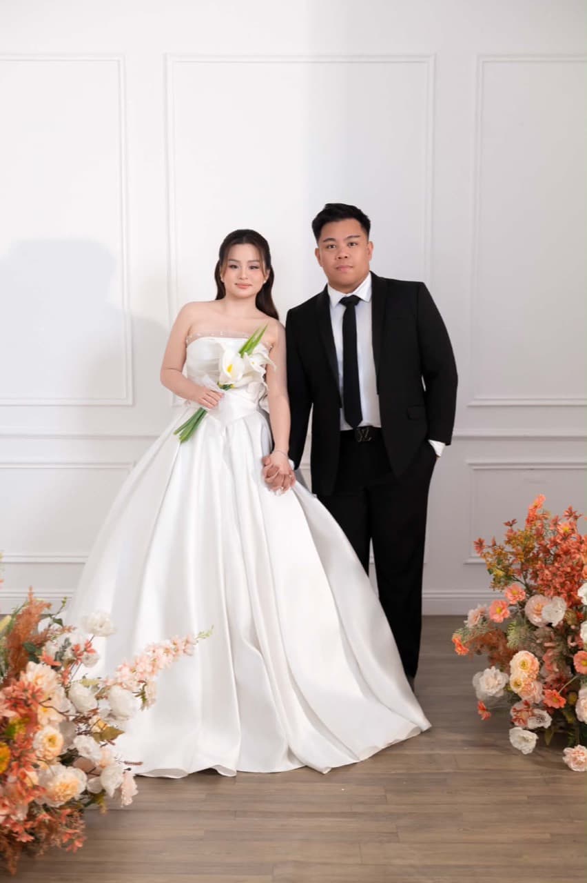 Paul and Maria holding hands, surrounded by flowers