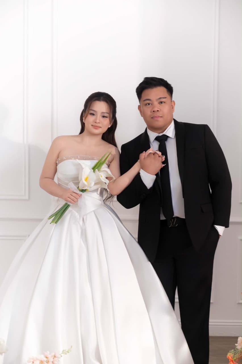 Paul and Maria holding hands in their wedding attire